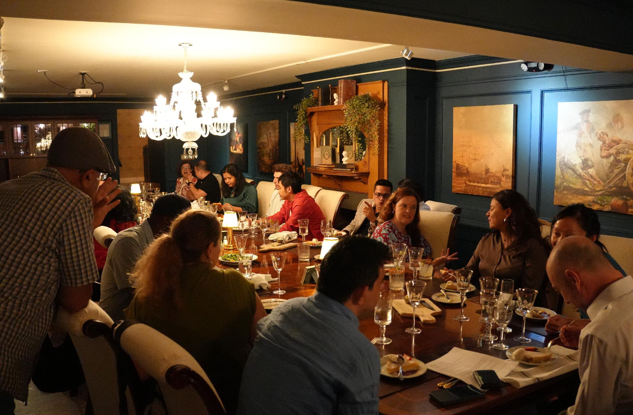 Guests dining together under a chandelier at Fraunces Tavern